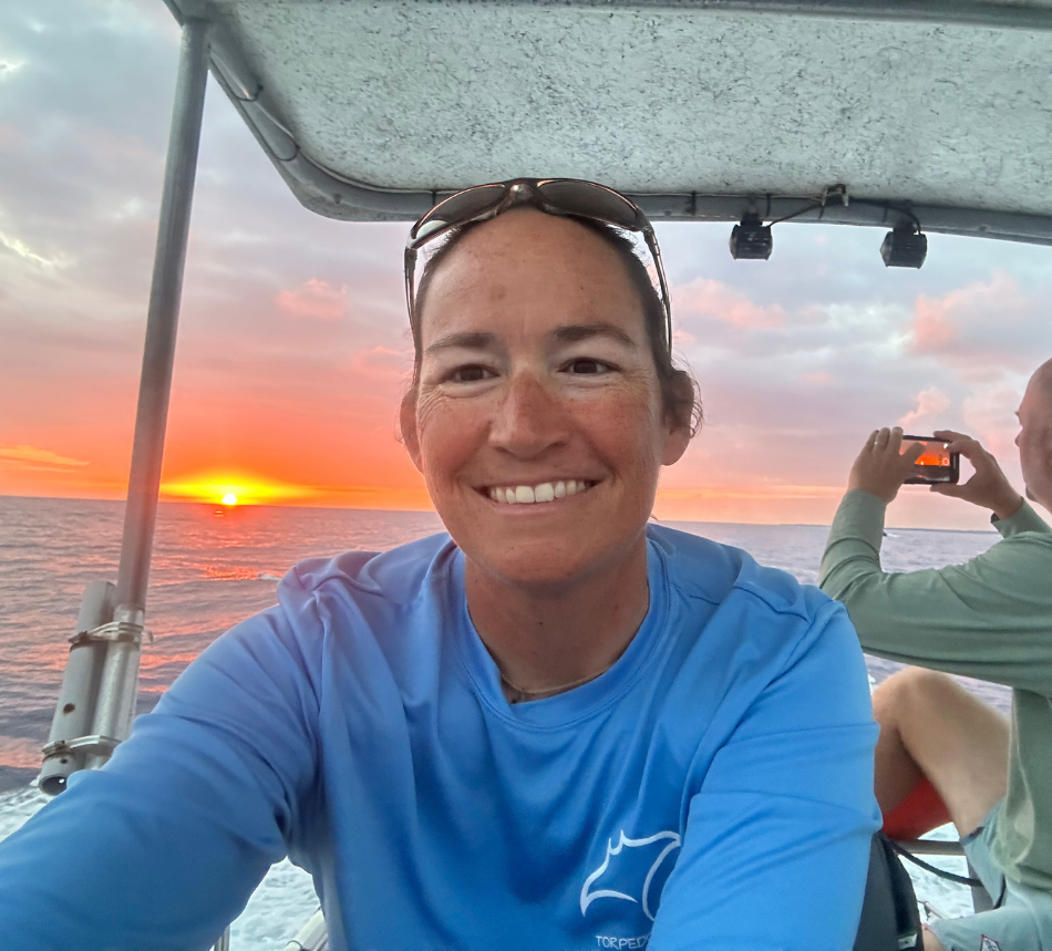 Photo of Ryan with a sunset on the boat.